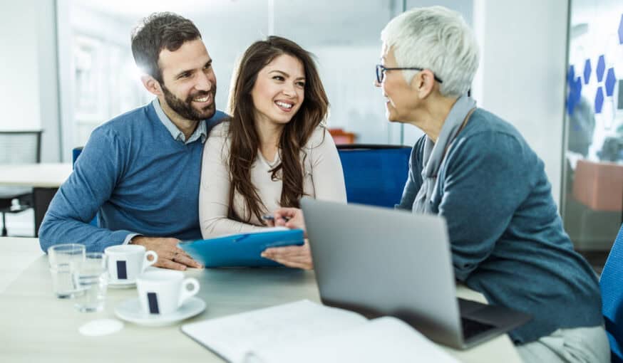 happy couple talking to their insurance agent on a meeting in the office.