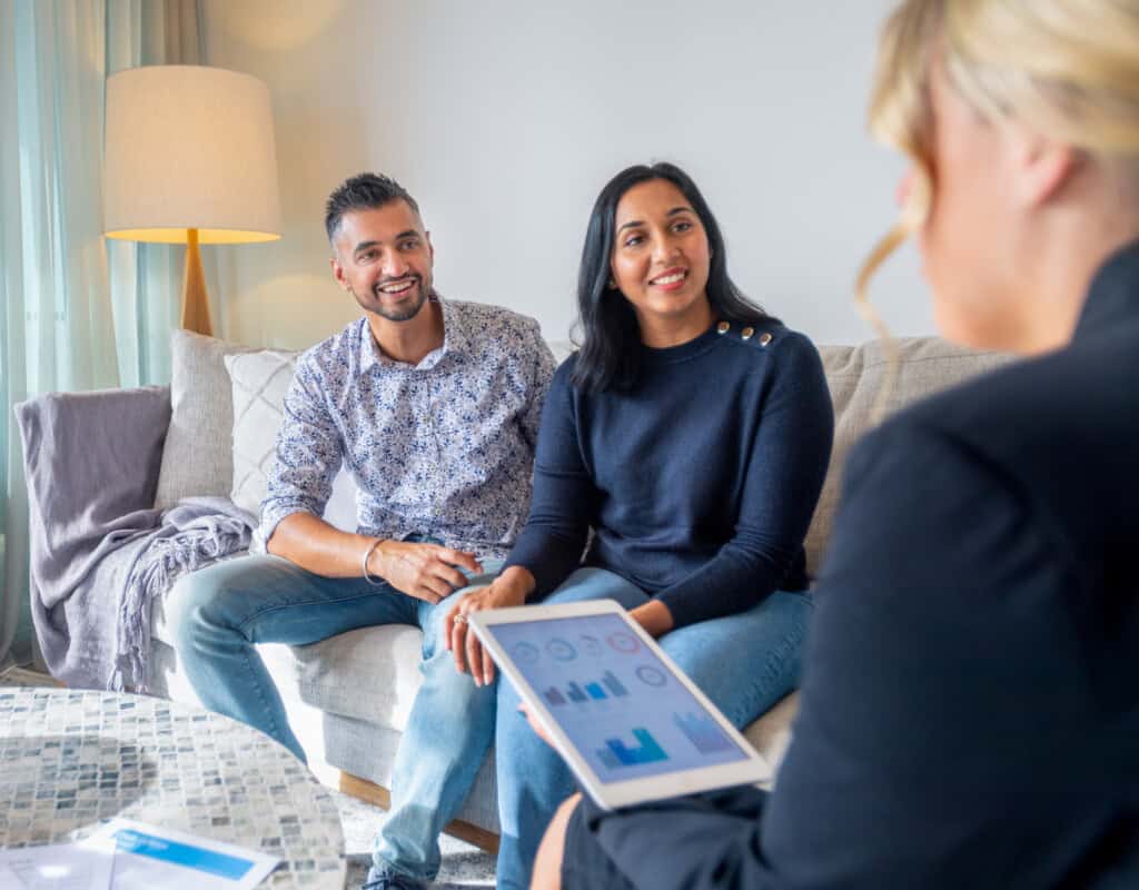 happy mature couple meeting with financial advisor or real estate agent at home