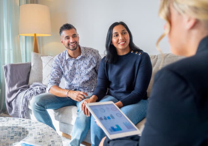 happy mature couple meeting with financial advisor or real estate agent at home