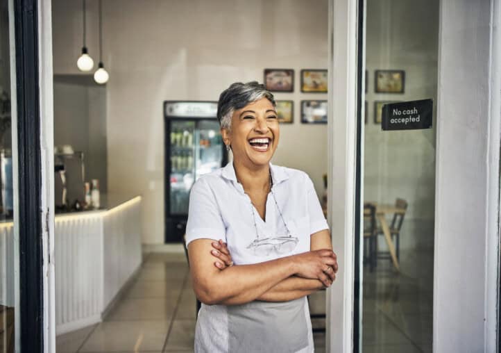 coffee shop, small business and a woman laughing at front door with pride for cafe or restaurant. startup entrepreneur person or waitress happy about service, management and hospitality at store