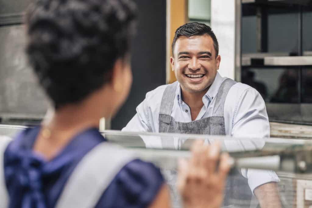 barista laughing at cafe counter